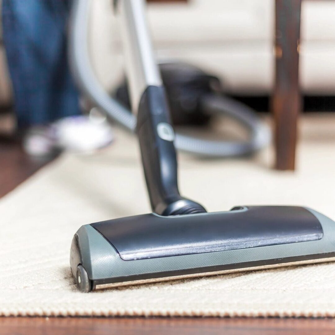 fm=f_3502 A vacuum cleaner is on the floor near a chair.